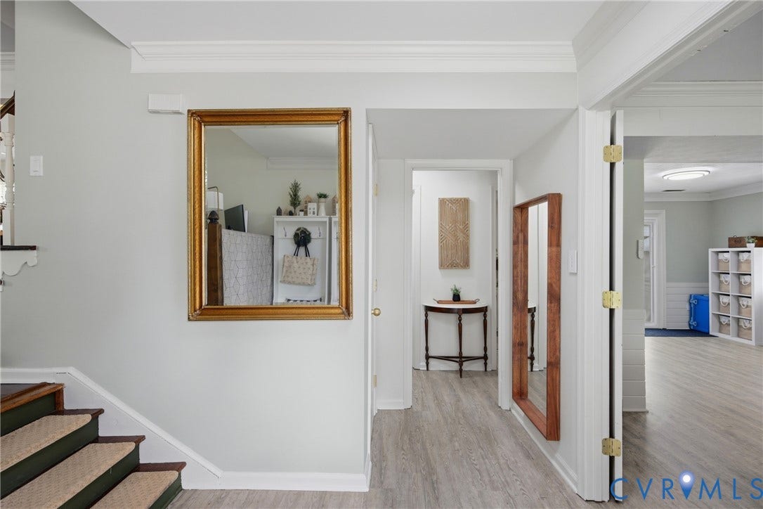 Entryway featuring light wood-finish flooring, white baseboards, and crown molding