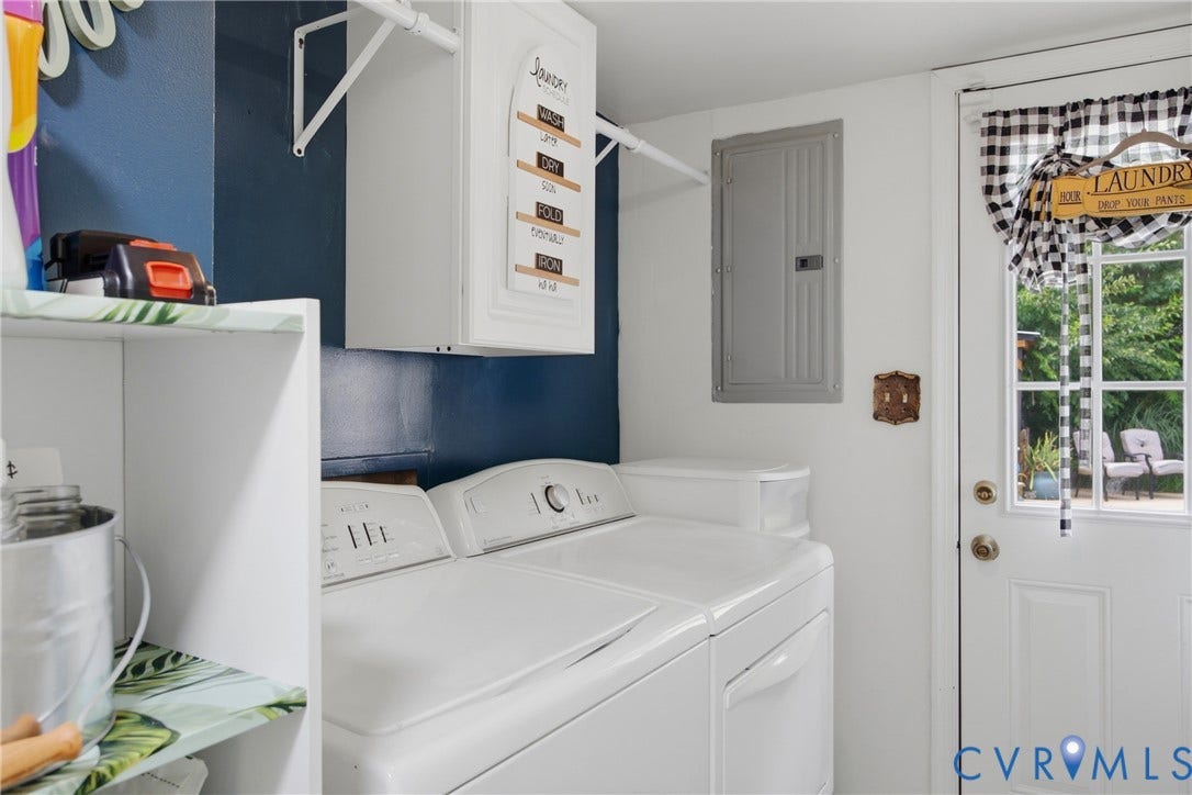 Dedicated laundry space featuring white appliances, a wall-mounted cabinet, and open shelving