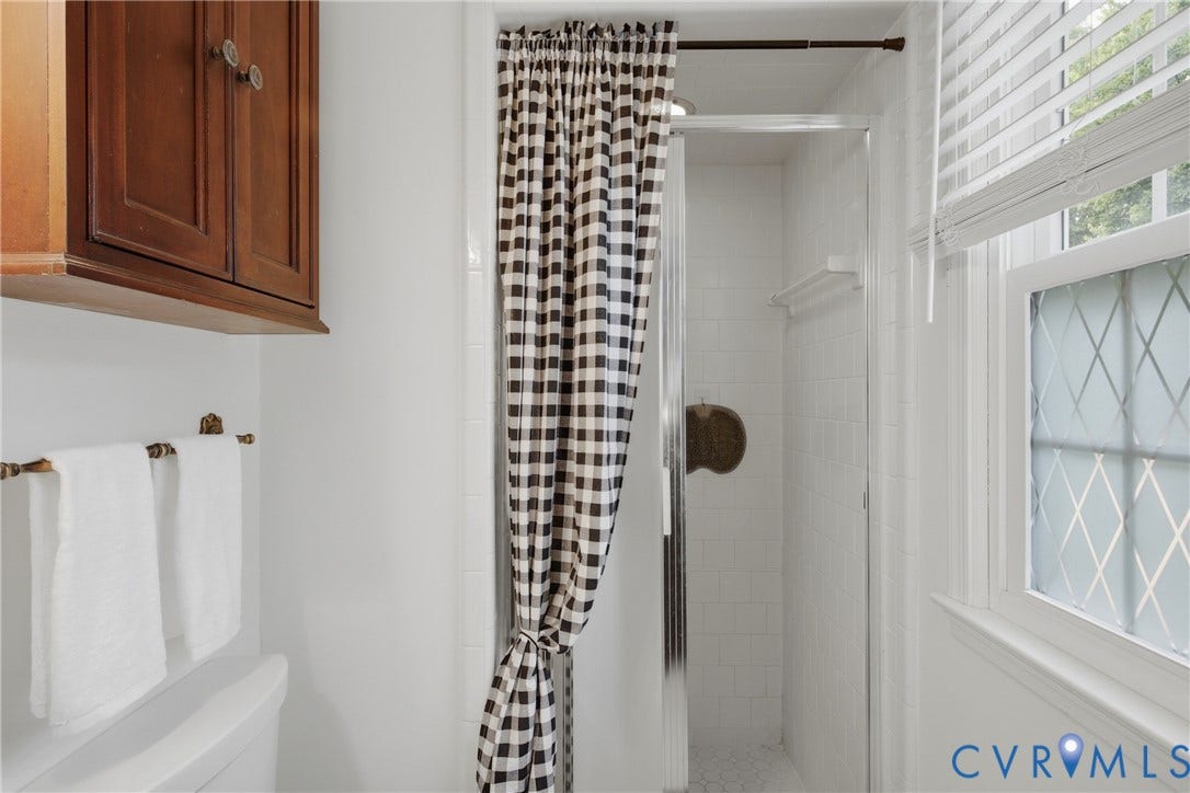 Shower stall with glass enclosure and white subway tile surround