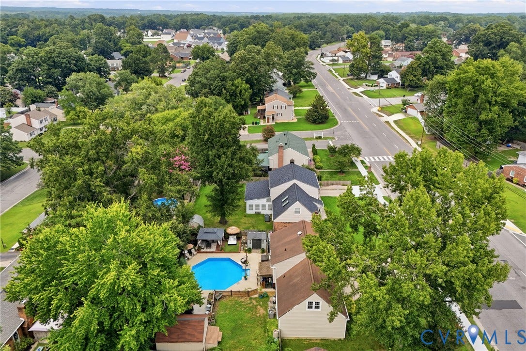 Expansive property with a blue-tiled swimming pool and surrounding paved patio