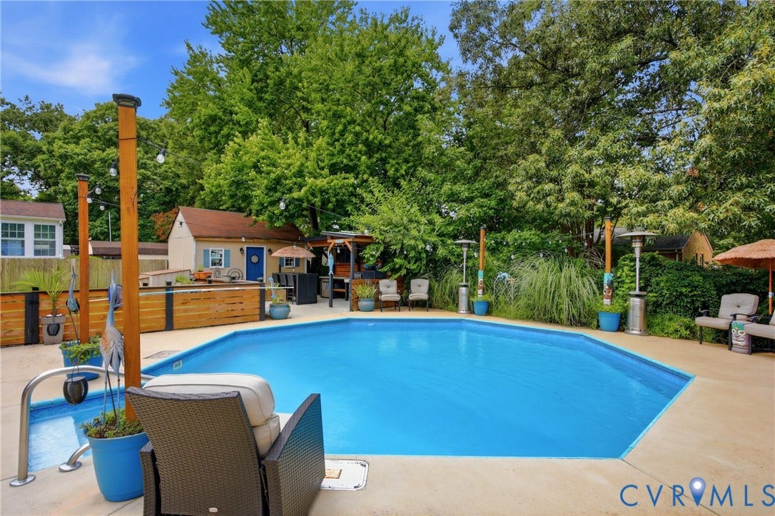 Octagonal swimming pool with integrated spa area, surrounded by a paved patio