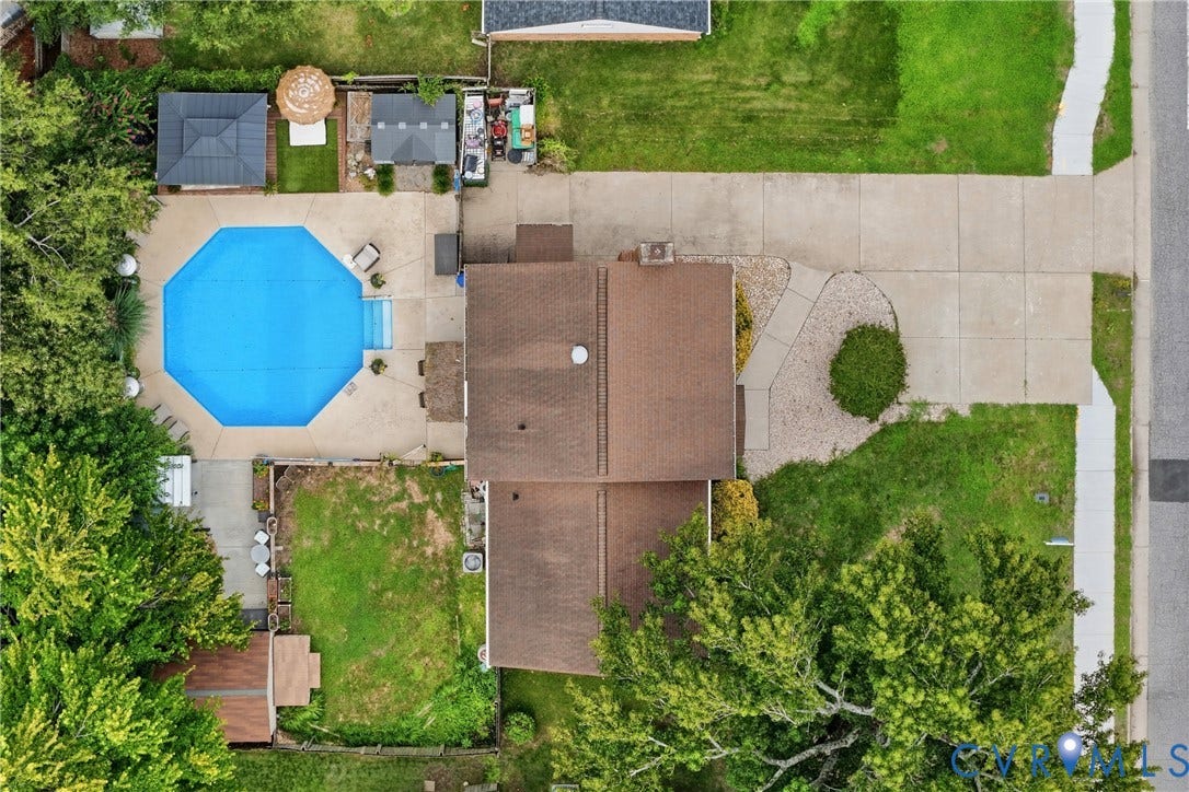 Expansive rear yard featuring an octagon-shaped swimming pool with a concrete surround