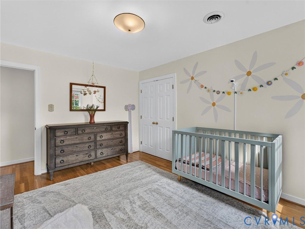 Light-colored wall finishes, wood-finish flooring, and a flush-mount ceiling light fixture