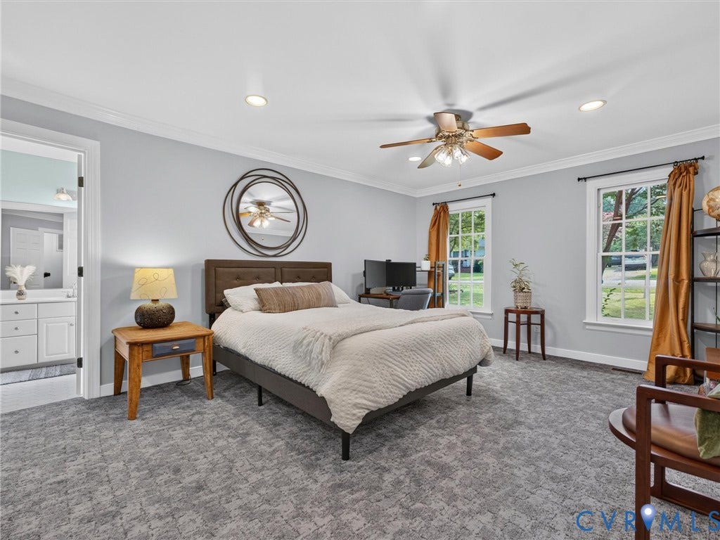 Spacious room featuring patterned carpet, two windows, crown molding, and recessed lighting