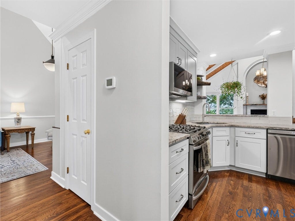 Kitchen featuring stainless steel appliances, white cabinetry, undermount sink, and granite countertops