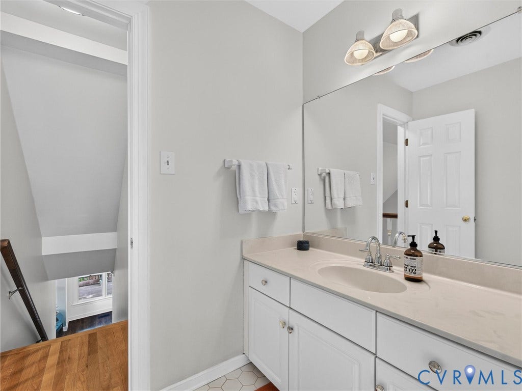 Spa-inspired bathroom featuring a generous vanity with dual sink configuration, ample storage cabinetry, and quartz countertop
