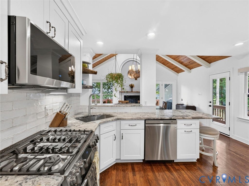 Updated kitchen with white cabinetry and stainless steel appliances