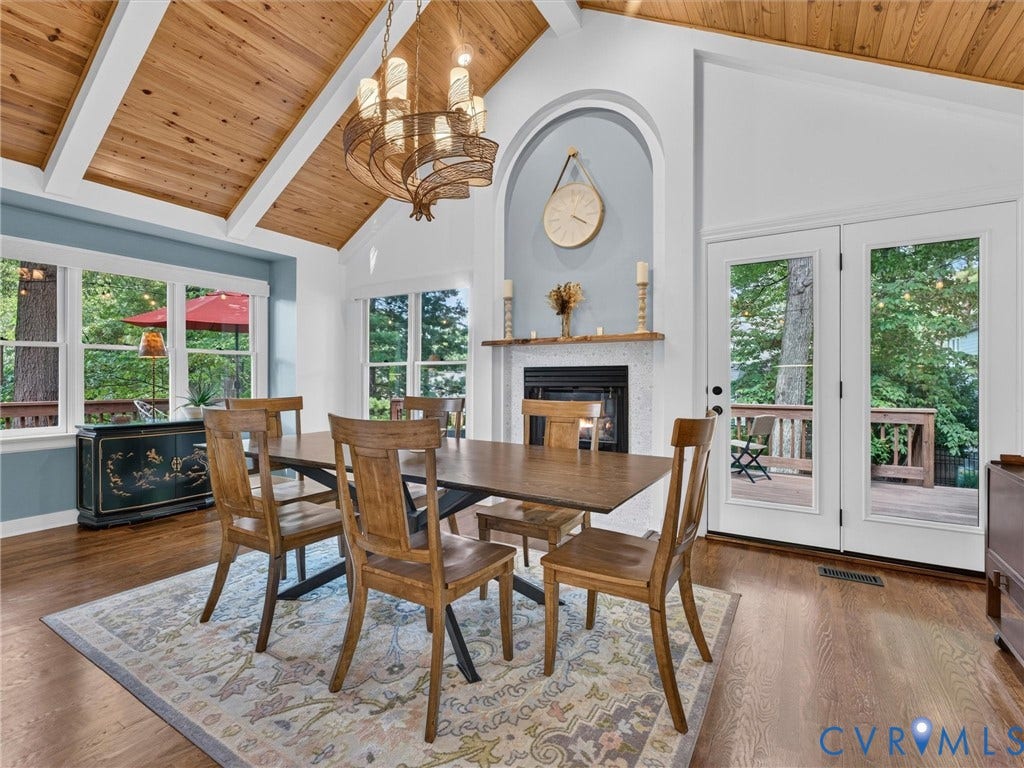 Vaulted wood-finish ceilings, wood-finish flooring, and a built-in fireplace with an arched alcove