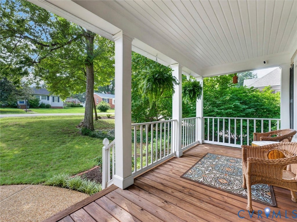 Expansive front porch featuring wood flooring, white railings, and a white beadboard ceiling