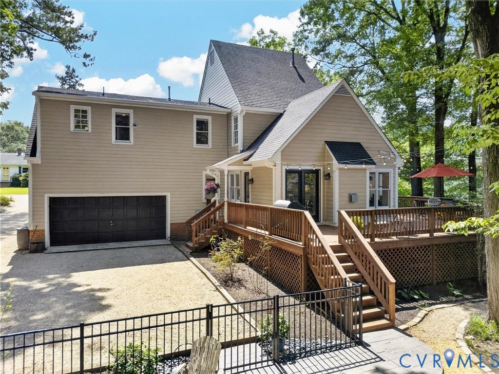 Expansive rear deck with wood railing, multi-level design, and direct access to interior
