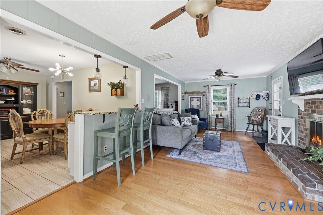 3300 Woodsong Drive, Midlothian, VA 23112 Living area featuring wood-finish flooring, a brick fireplace with a white mantel, and ceiling fans