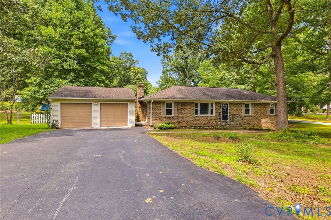 3300 Woodsong Drive, Midlothian, VA 23112 Brick ranch-style home featuring a two-car garage, asphalt driveway, mature trees, and a front porch with railings
