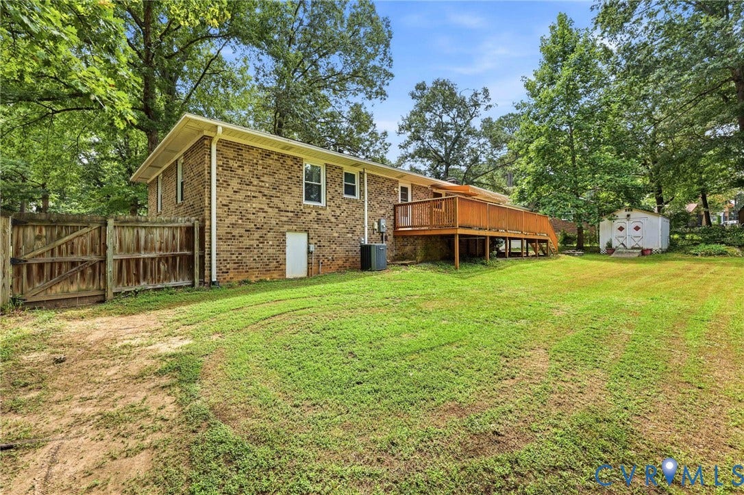 3300 Woodsong Drive, Midlothian, VA 23112 Expansive rear yard featuring a large wood deck, mature trees, a storage shed, and a privacy fence