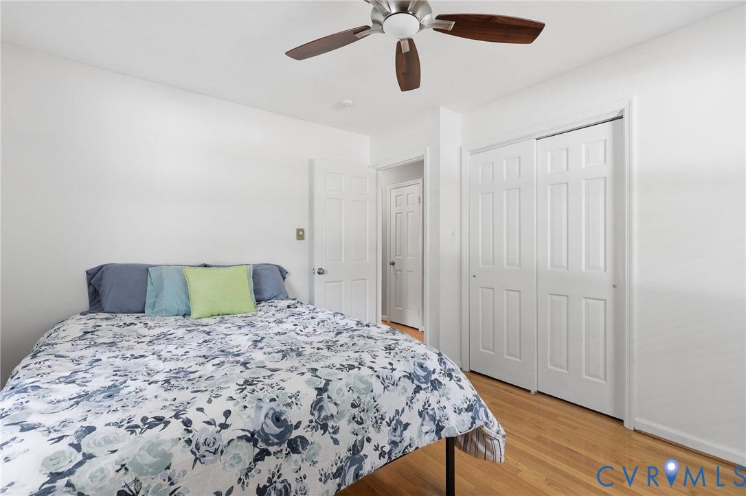 3300 Woodsong Drive, Midlothian, VA 23112 Bedroom featuring wood-finish flooring, a ceiling fan with wood-tone blades, a paneled door, and bi-fold closet doors