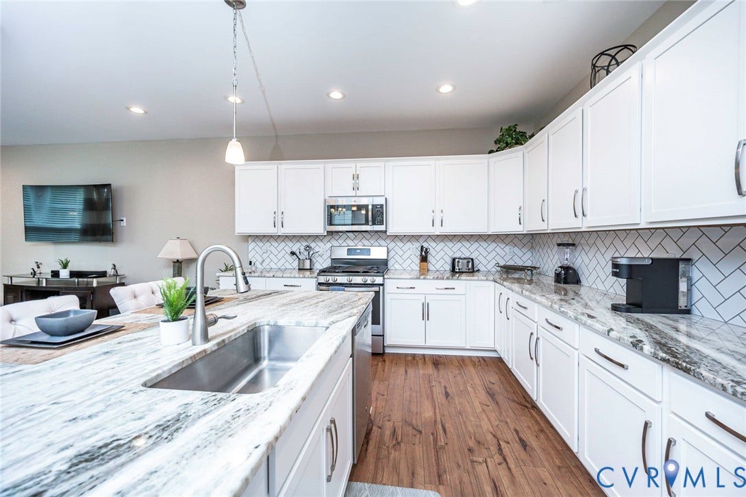 7205 Desert Candle Drive, Moseley, VA 23120 Kitchen featuring an oversized island with an undermount stainless steel sink and a pull-down faucet