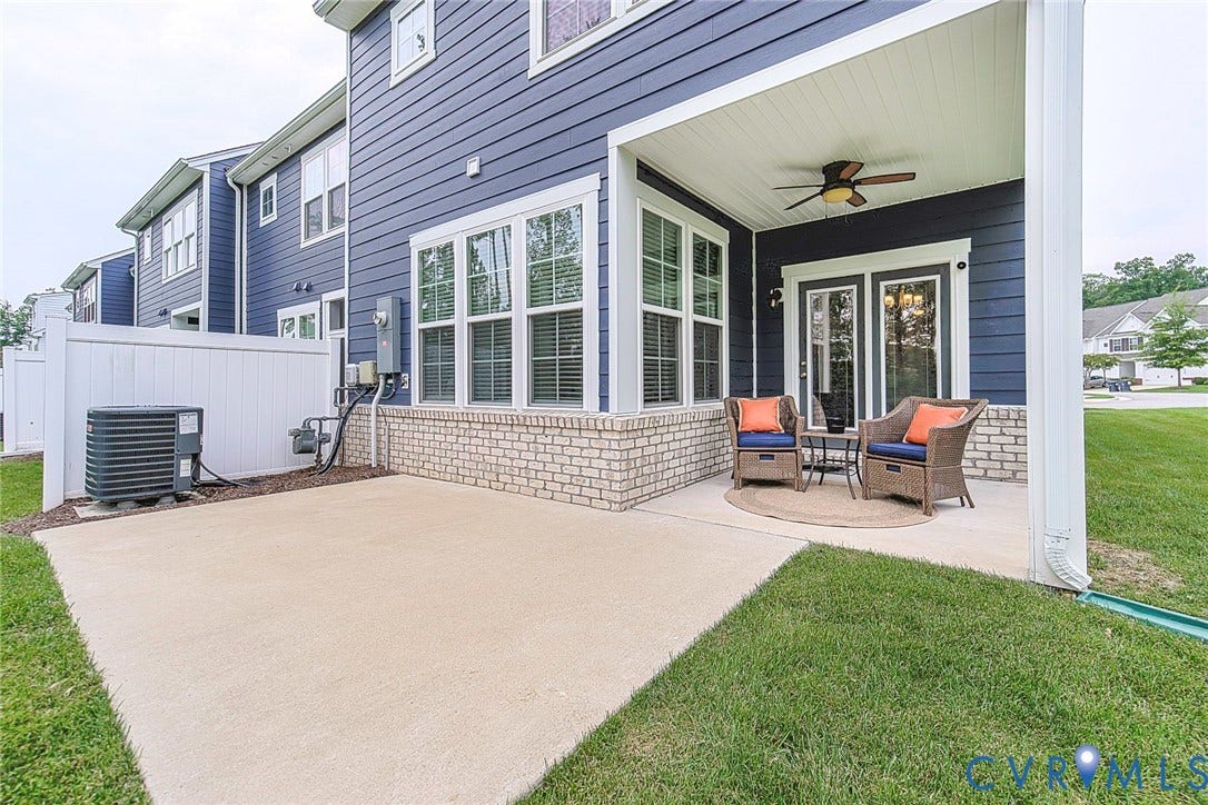 7205 Desert Candle Drive, Moseley, VA 23120 Private patio featuring a covered seating area with a ceiling fan, white vinyl fencing, concrete patio surface, and a brick base along the exterior wall
