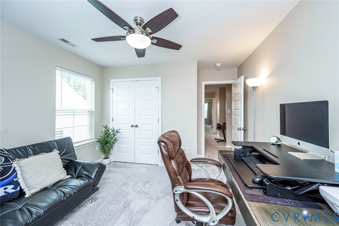 7205 Desert Candle Drive, Moseley, VA 23120 Versatile interior space featuring light gray wall paint, textured carpeting, and a ceiling fan with integrated lighting