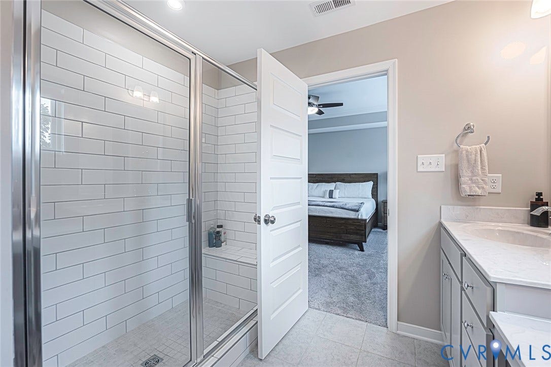 7205 Desert Candle Drive, Moseley, VA 23120 Glass-enclosed shower with white subway tile surround and integrated bench
