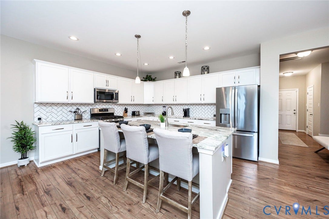 7205 Desert Candle Drive, Moseley, VA 23120 Modern kitchen featuring white cabinetry, stainless steel appliances, a herringbone tile backsplash