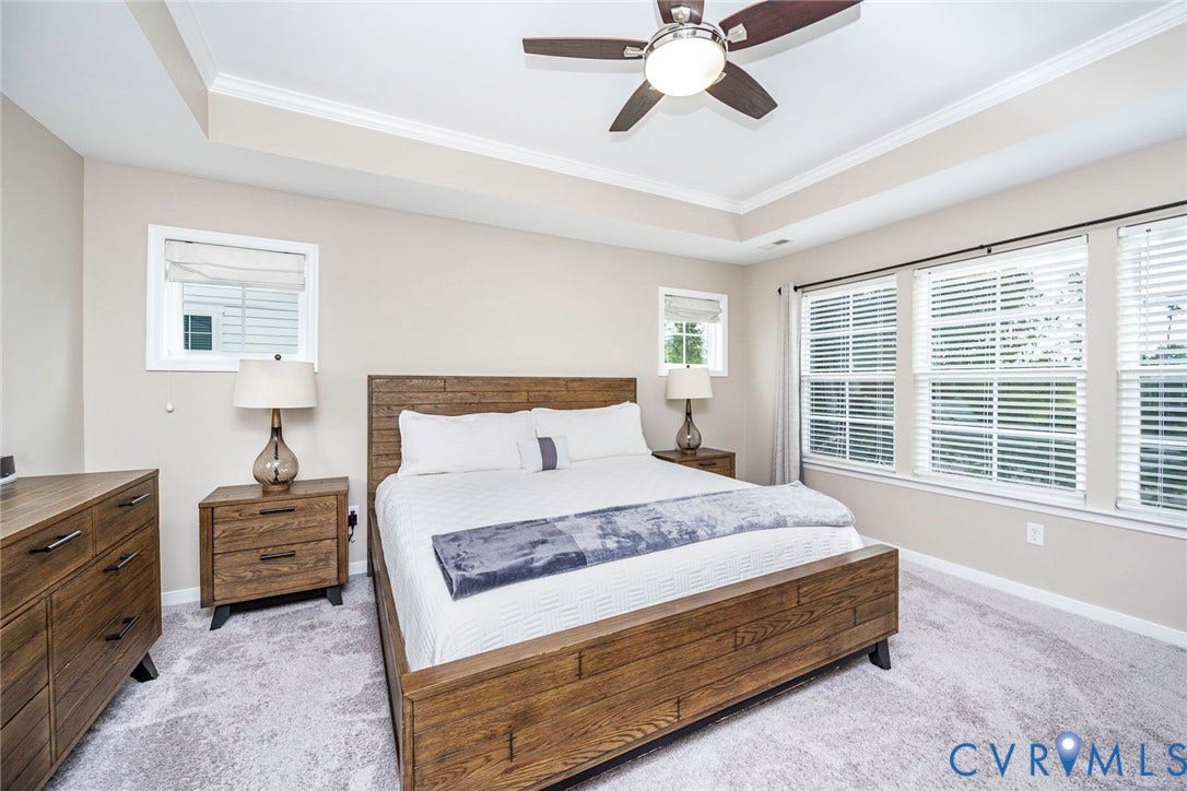 7205 Desert Candle Drive, Moseley, VA 23120 Primary bedroom featuring tray ceiling with crown molding, ceiling fan, and light-toned wall finishes