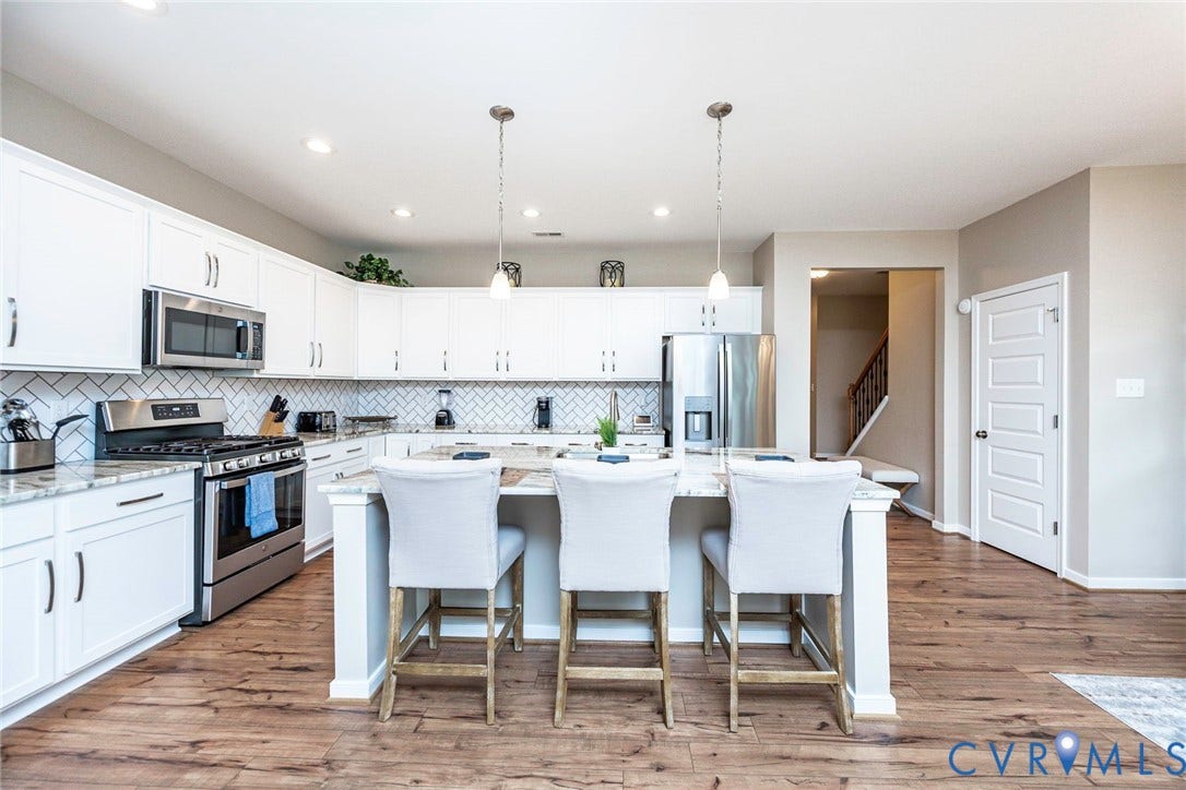7205 Desert Candle Drive, Moseley, VA 23120 Modern kitchen featuring white cabinetry, stainless steel appliances, and wood-finish flooring