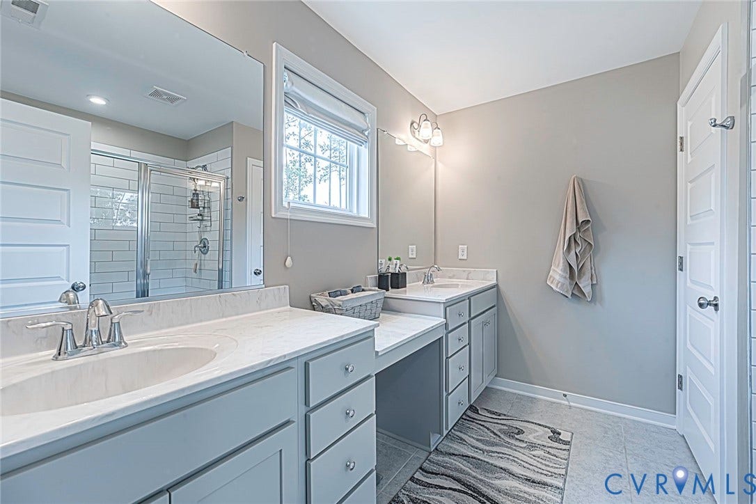 7205 Desert Candle Drive, Moseley, VA 23120 Primary bath featuring dual vanities with undermount sinks and light-toned countertops