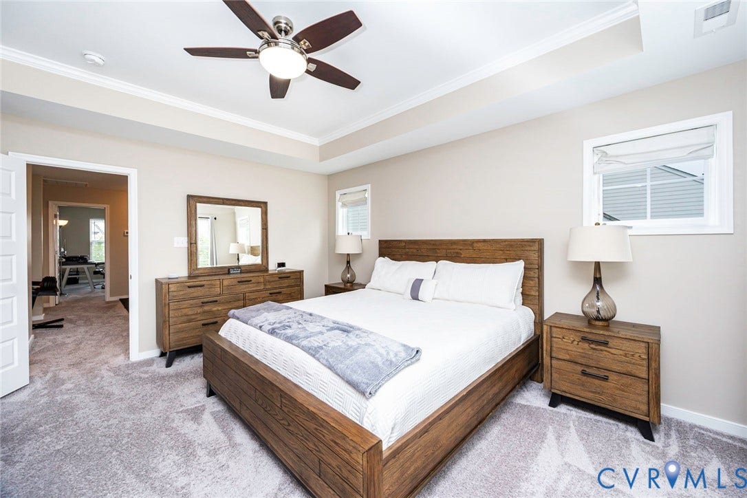7205 Desert Candle Drive, Moseley, VA 23120 Spacious room featuring a tray ceiling with crown molding, a ceiling fan with integrated lighting, and neutral wall paint
