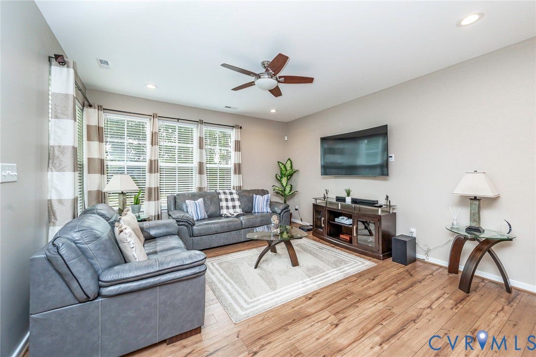 7205 Desert Candle Drive, Moseley, VA 23120 Living area featuring, three large windows with white blinds, a ceiling fan with integrated lighting, recessed lighting, and neutral wall paint