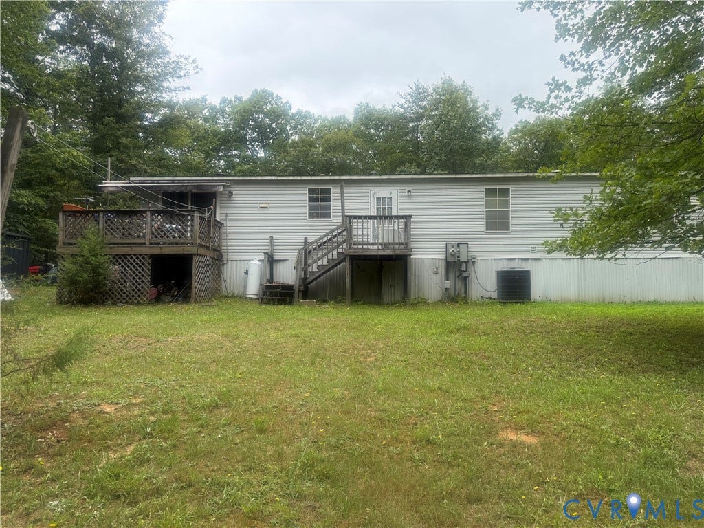 652 Mallorys Ford Road, Cool Springs, Louisa, VA 23093 Rear exterior featuring light-colored siding, a multi-level wood deck, and a separate wood staircase leading to a rear entry door