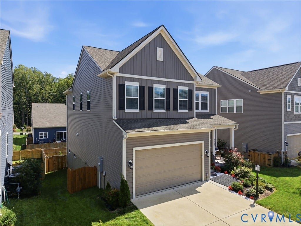 Contemporary two-story residence featuring grey horizontal siding and a dark brown garage door