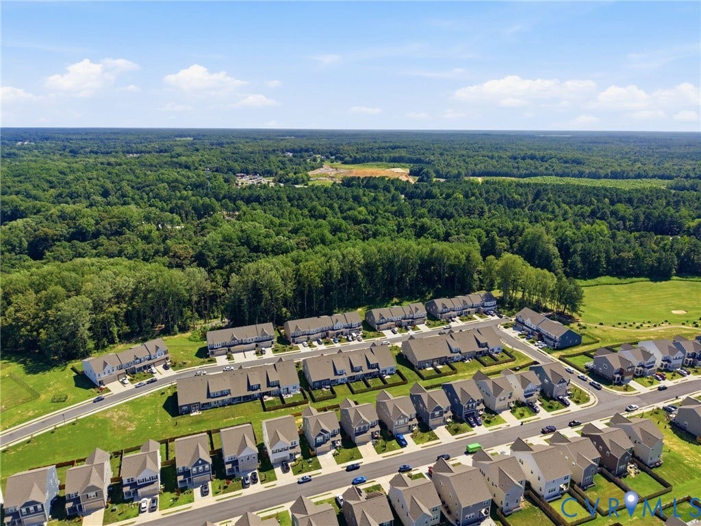 Established residential community featuring multiple townhome-style residences with uniform architectural design, pitched rooflines, and brick exteriors