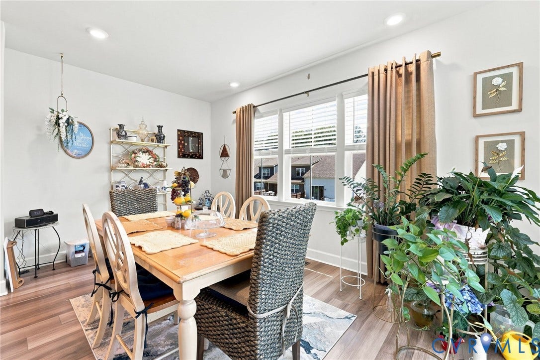 Spacious dining area featuring wood-finish flooring, recessed lighting, and a large window with horizontal blinds