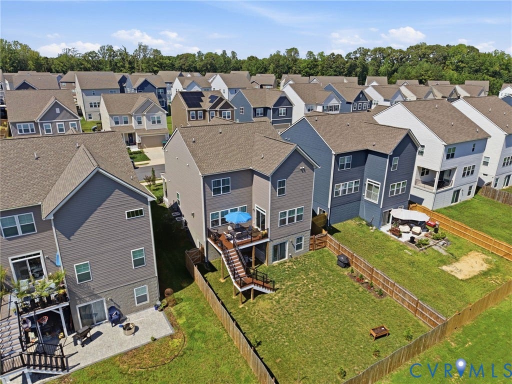 Rear exterior featuring a multi-level wood deck, a patio with pavers, and a fenced lawn