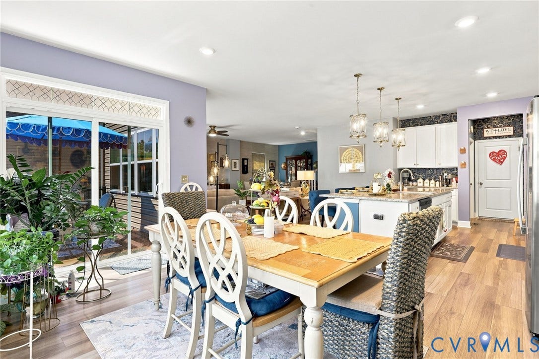 Open-concept dining area with wood-finish flooring, recessed lighting, and sliding glass doors