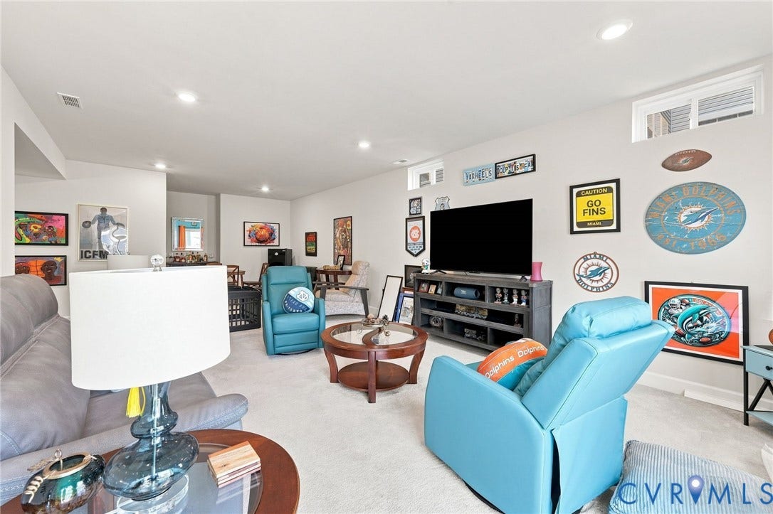 Expansive finished room with recessed lighting and carpet flooring, featuring a media center with storage and high-set windows