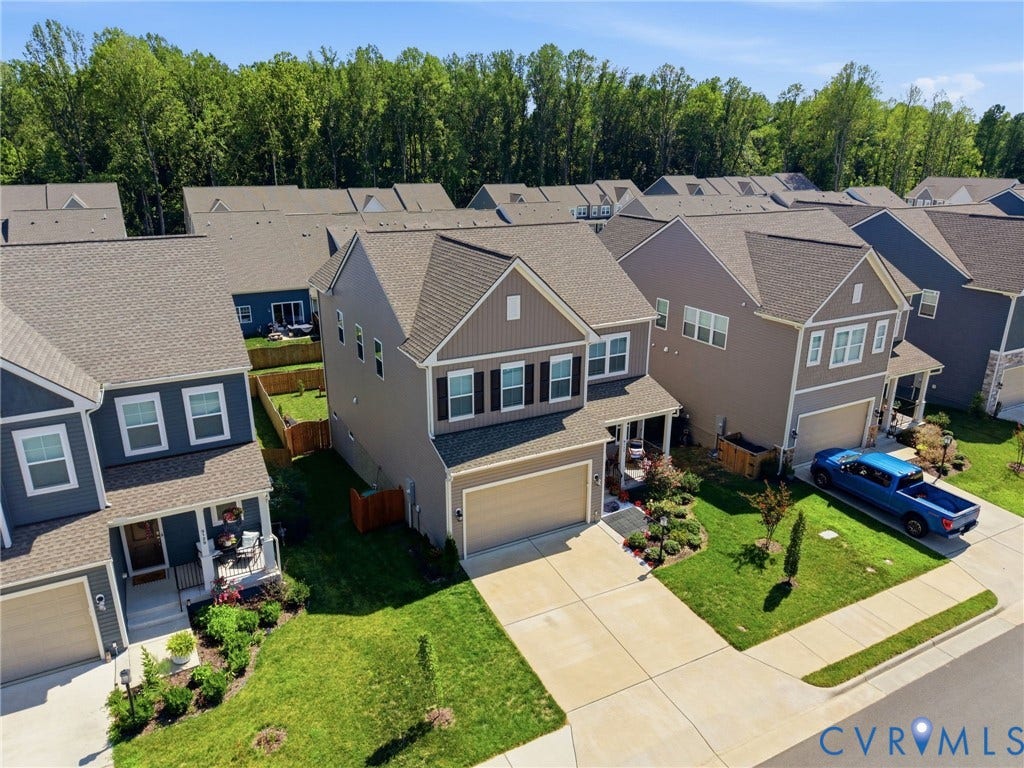 Modern two-story residence featuring a two-car garage, covered entry porch, and partial stone facade accents