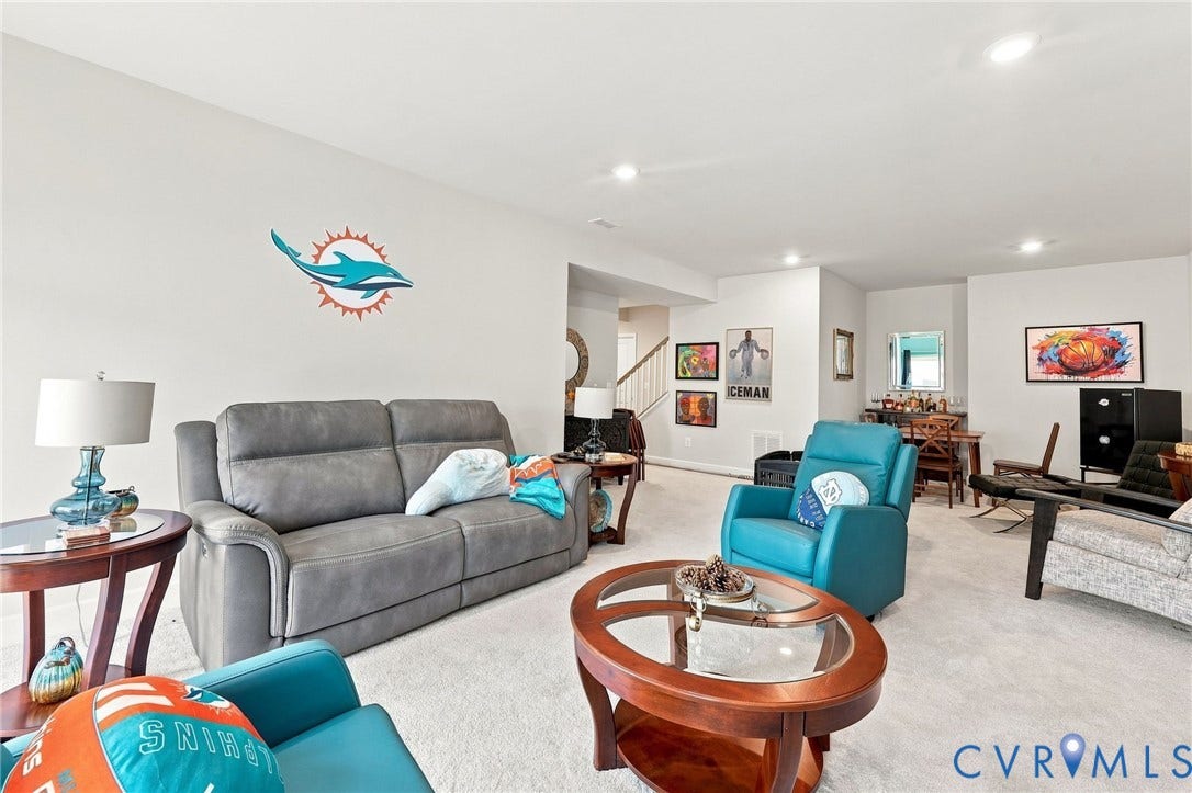 Spacious living area featuring light-colored carpeting and recessed lighting