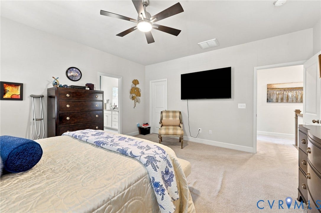 Spacious primary bedroom featuring neutral wood-finish flooring, recessed lighting, and a ceiling fan with integrated light fixture