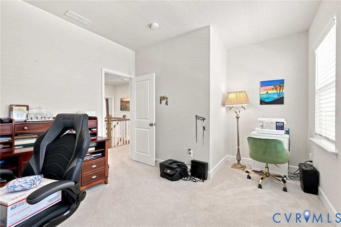 Carpeted room with a white door, white trim, and a window with horizontal blinds