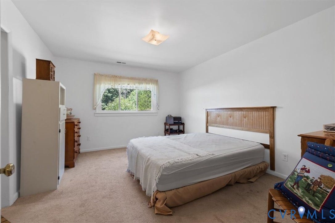 2311 Georges Road, Powhatan, VA 23139 Carpeted interior space featuring light-colored walls and a window with exterior tree scenery