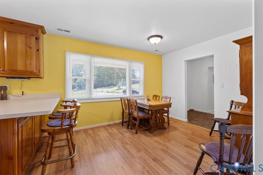 2311 Georges Road, Powhatan, VA 23139 Bright kitchen space featuring wood-finish flooring, light-toned countertops, wooden cabinetry, and a multi-pane window
