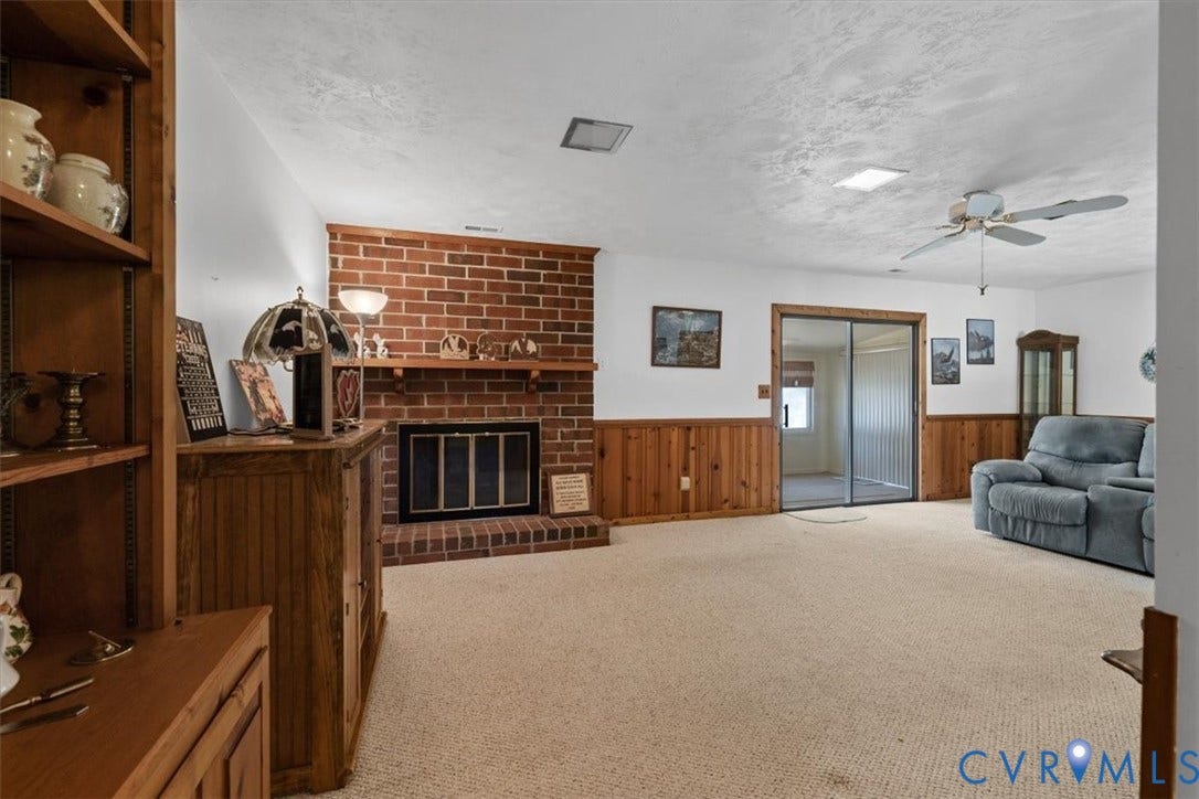 2311 Georges Road, Powhatan, VA 23139 Brick fireplace with a black firebox and a wood mantel