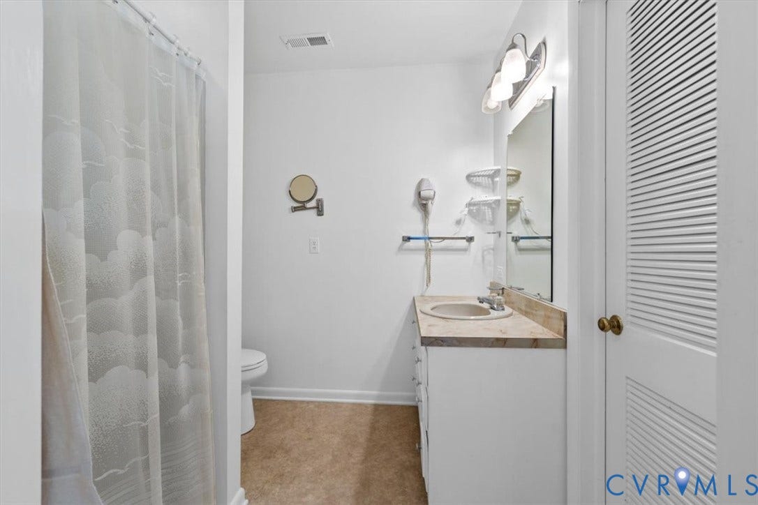 2311 Georges Road, Powhatan, VA 23139 Bathroom featuring a single vanity with an integrated sink, a light-colored countertop, and a wall-mounted mirror