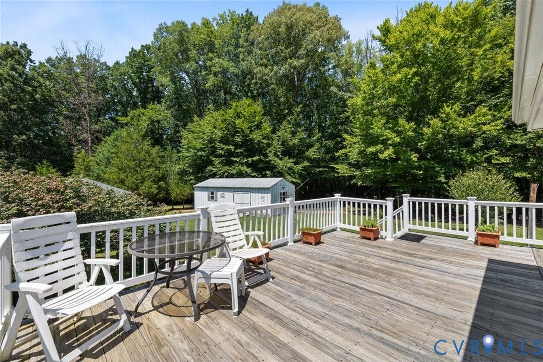 2311 Georges Road, Powhatan, VA 23139 Expansive wooden deck featuring white baluster railings and a detached storage shed