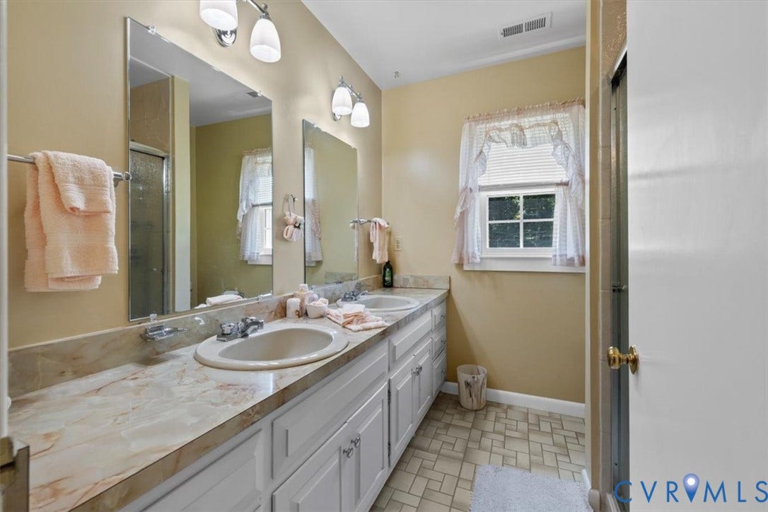 2311 Georges Road, Powhatan, VA 23139 Double vanity featuring two integrated sinks, a patterned countertop, and white shaker-style cabinetry