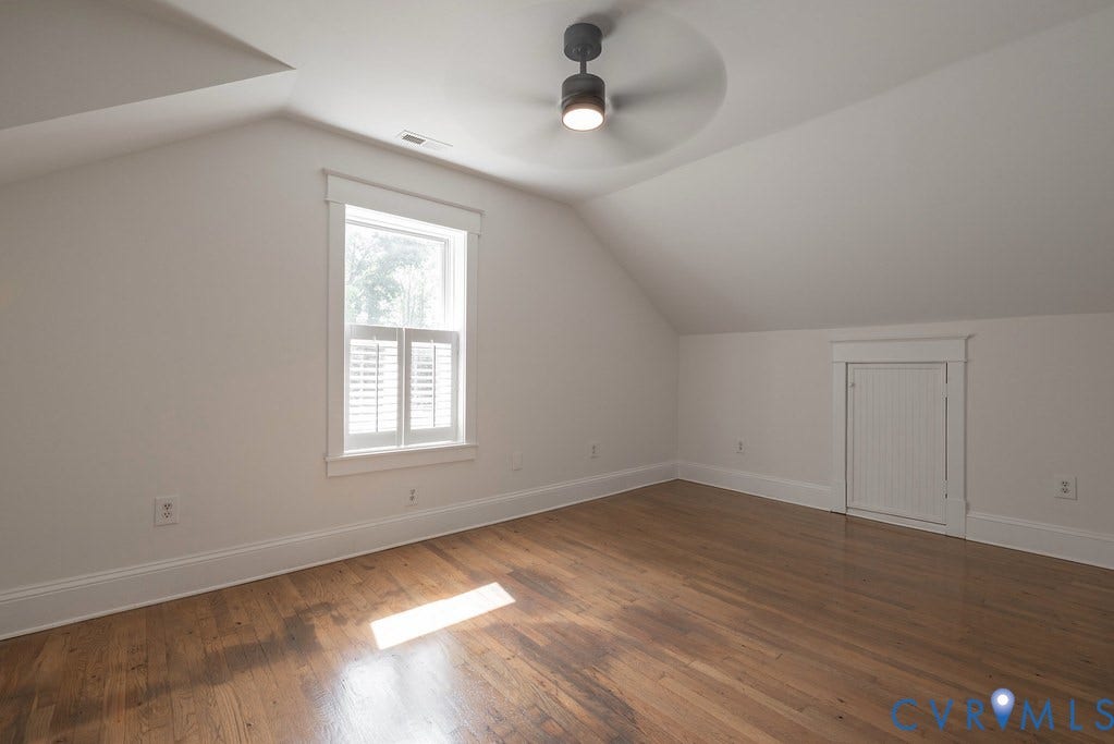 4808 River Road W Road, Goochland, VA 23063 Third bedroon, wood-finish flooring, a contemporary ceiling fan with integrated lighting, a window with plantation shutters, and a built-in storage access door with beadboard paneling