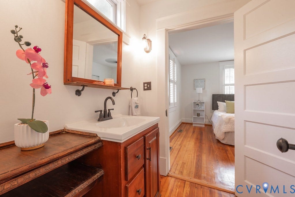 4808 River Road W Road, Goochland, VA 23063 Bathroom vanity with a wood-finish cabinet, integrated sink, and an overhead wood-framed mirror