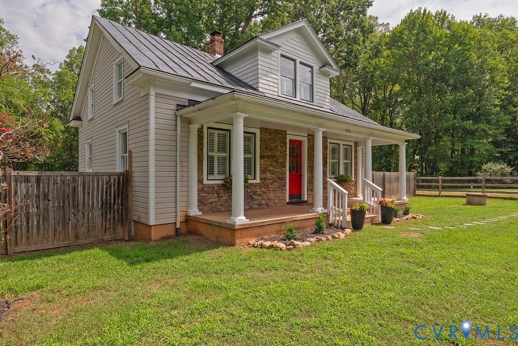 4808 River Road W Road, Goochland, VA 23063 Charming residence featuring a bright red front door, a covered porch with white columns and railings, a durable metal roof, and a stone facade accent