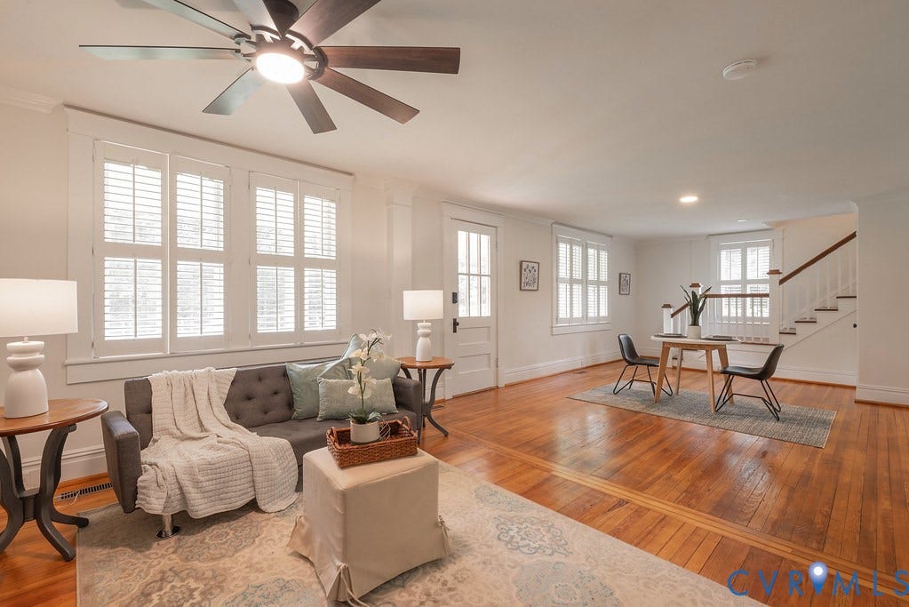 4808 River Road W Road, Goochland, VA 23063 Spacious living area featuring wood-finish flooring, white plantation shutters, and a dark-bladed ceiling fan