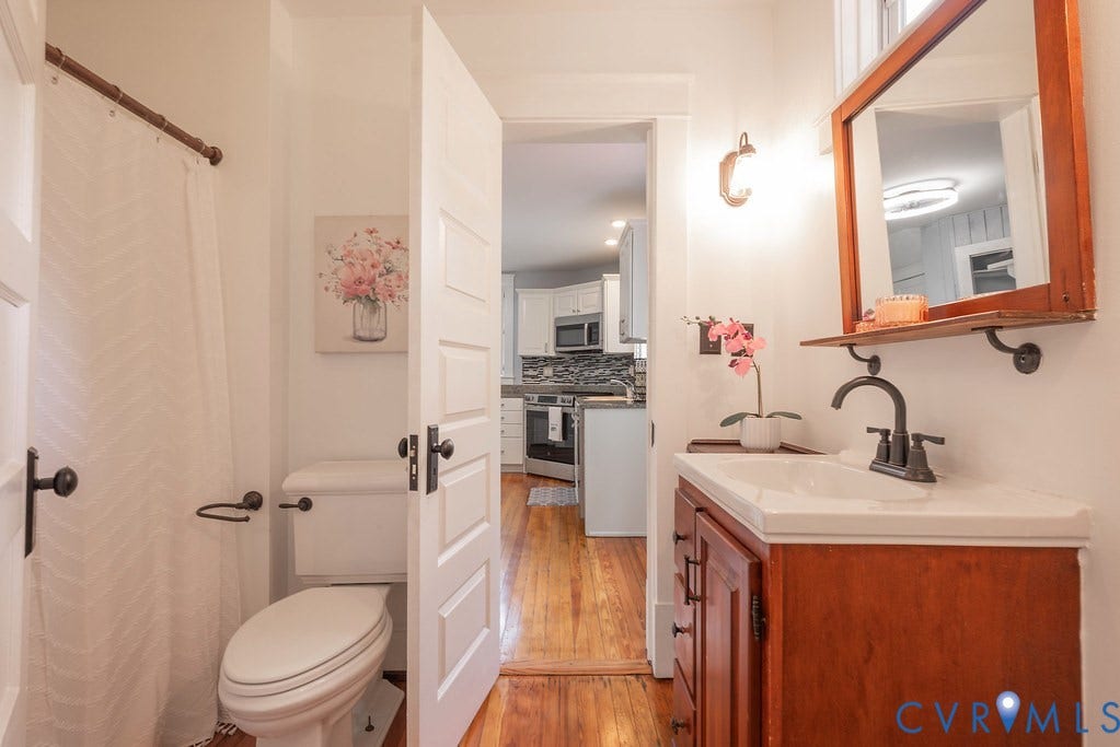 4808 River Road W Road, Goochland, VA 23063 Bathroom featuring a single-basin vanity with a wood cabinet, a white countertop, and a dark bronze faucet